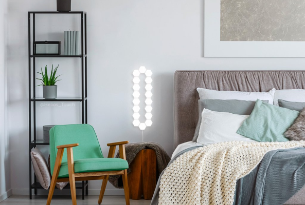 Ambiente de uma quarto moderno e bonito, usando o produto como luz de cabeceira.